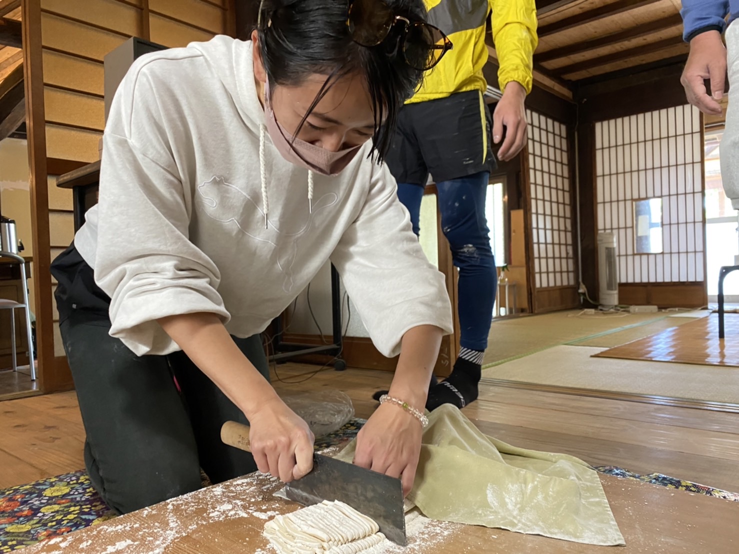 <p>手で丸めてこねて、足で踏んで踏んで、棒で伸ばして伸ばして、<br />触ったこともない大きな包丁で、同じ太さに切っていきます。<br /><br />「うまくできなくっても今まで体験した人、みーんなお腹に入ってるから大丈夫」という先生のお言葉にほっとし（笑）<br /><br />ワイワイにぎやかに、うどん作りを楽しみました！生地をこねた感触、踏んだ感触、切った時の感触・・・<br /><br />体験してみないとわからないから、ほんっと楽しかった！</p>